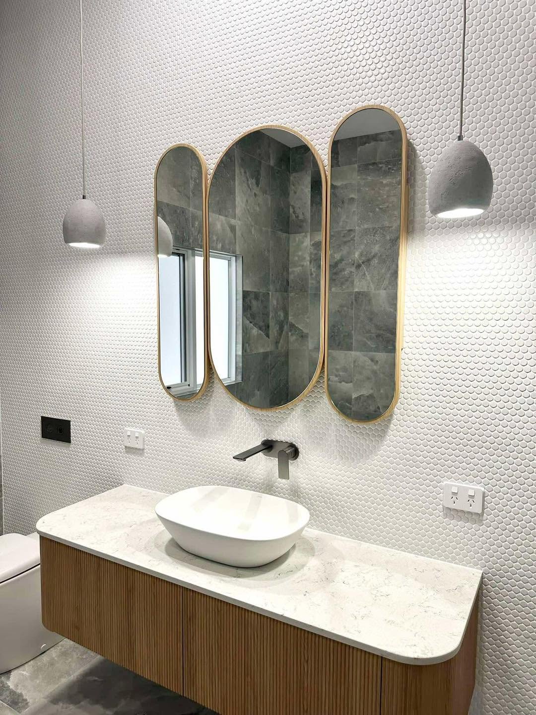 Honeycomb tile ensuite with triple oval gold mirrors