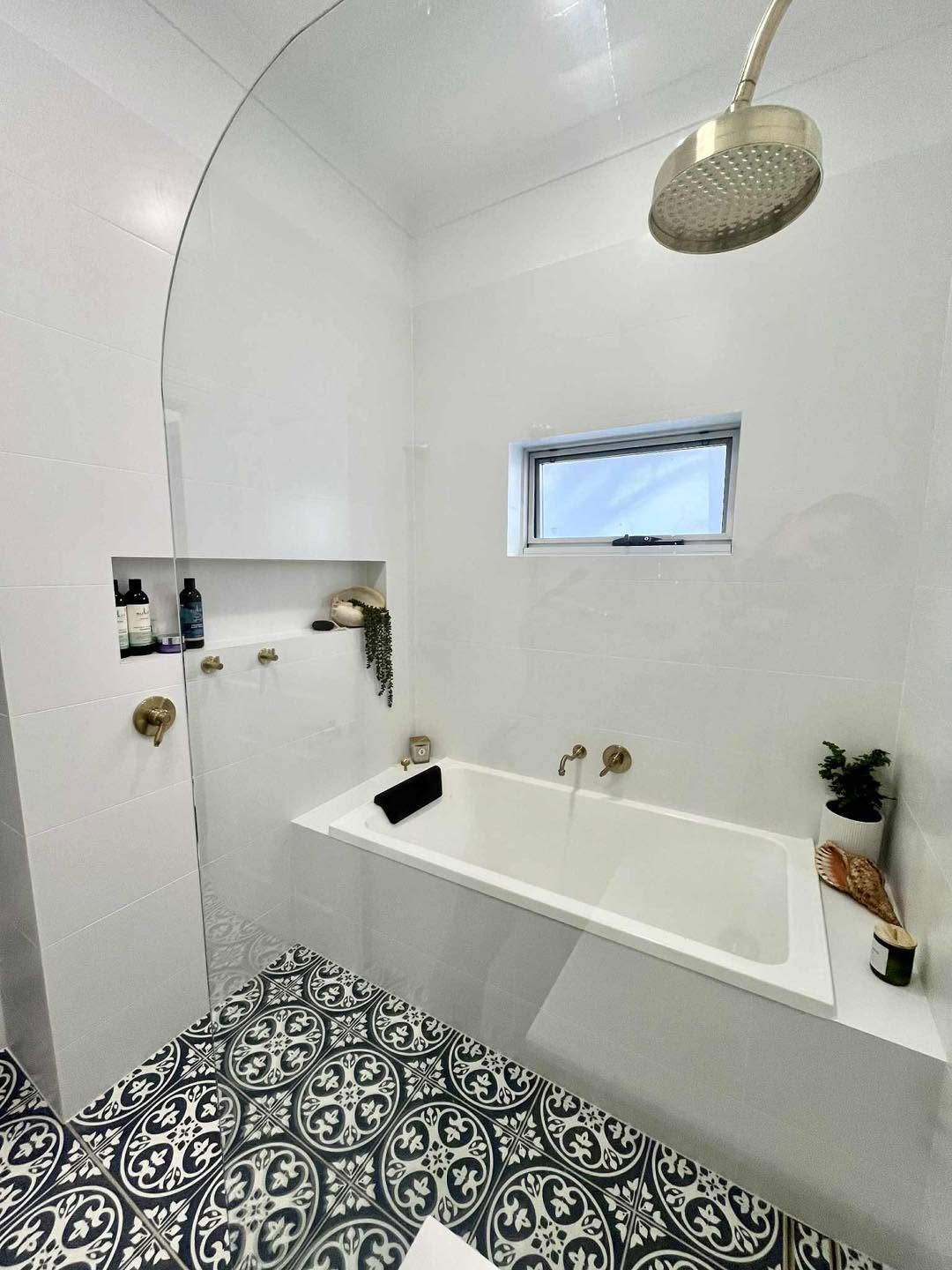 Bathroom with patterned Moroccan floor tiles and brass fixtures
