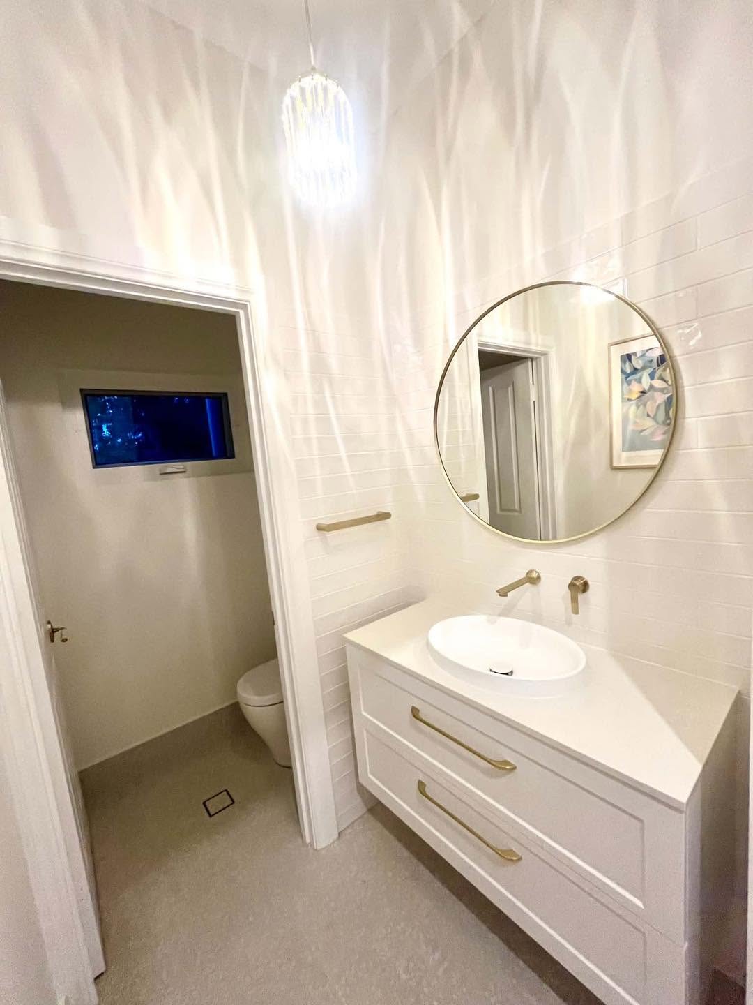 Elegant white bathroom with chandelier by Spriggs and Co Adelaide